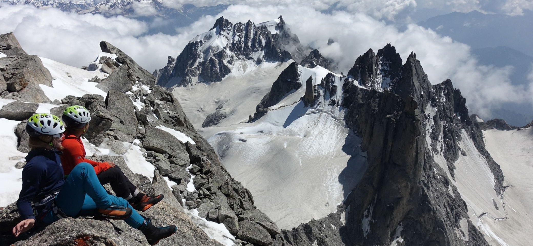 Zwei Bergsteiger sitzen auf dem Gipfel und genießen eine großartige Bergkulisse | © DAV/Expedkader